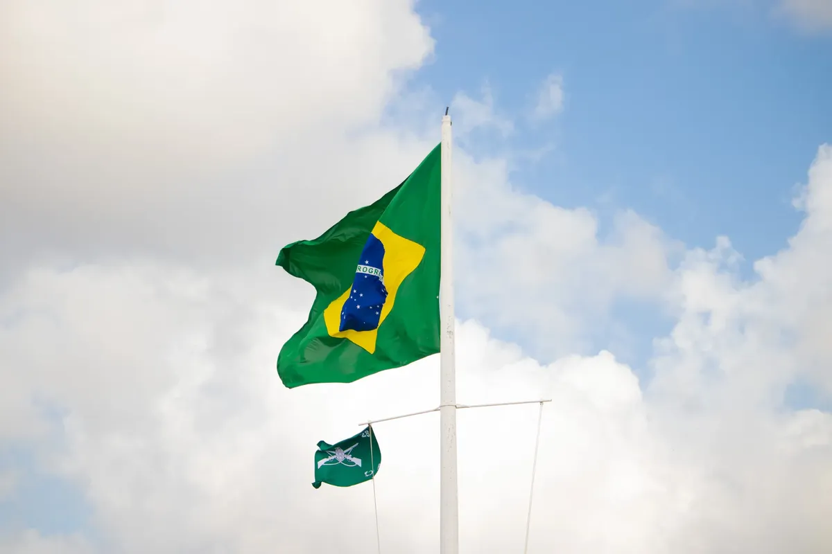 The Brazilian flag waving against a bright sky in Aracaju, Brazil.