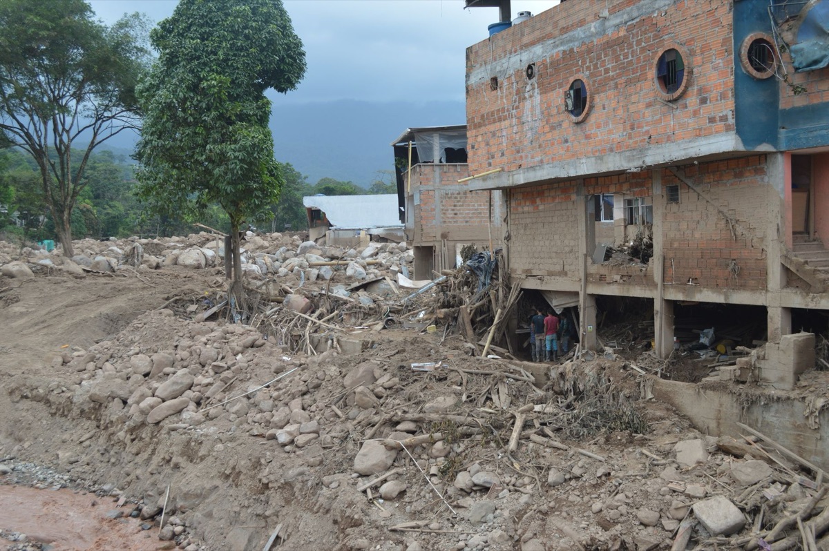 Heavy rain causes mudslide on Amazon hillside, silt flowing into once-clear stream.